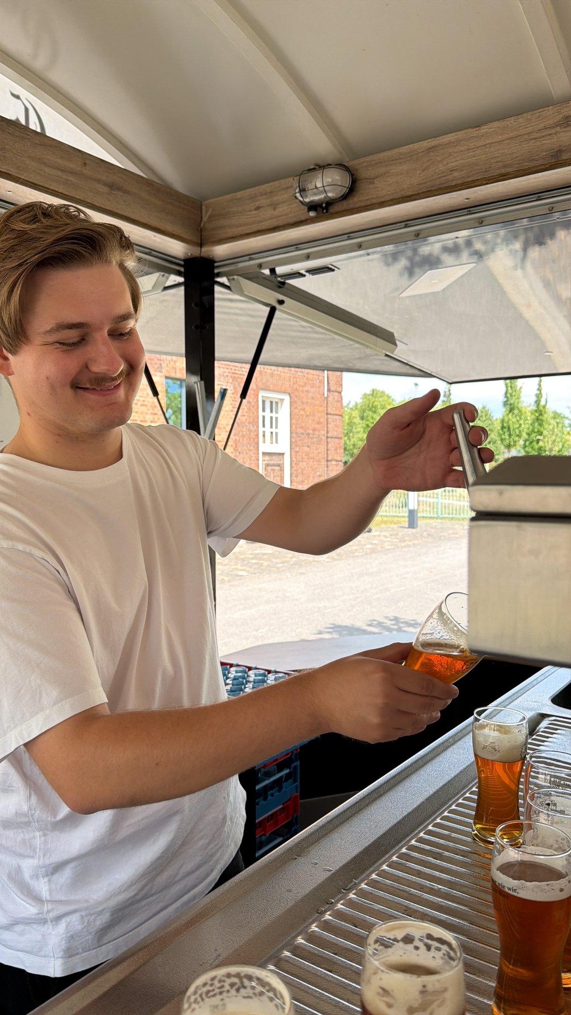 Ein junger Helfer zapft Bier am Getränkestand beim Kultursommer-Auftakt