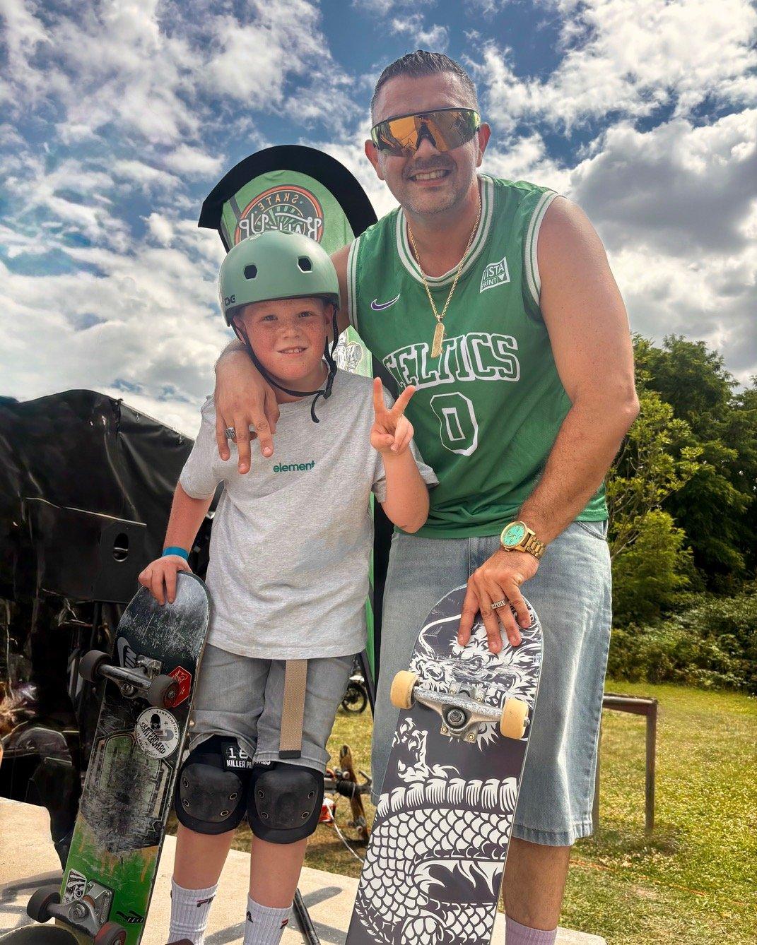 Ein Mann im Celtics-Trikot und ein Junge mit Skaterhelm zeigen das Victory-Zeichen