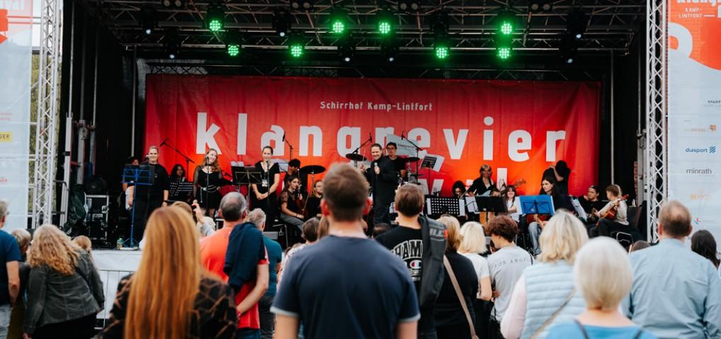 Das Jugend-Kinder-Rock-Orchester JuKiRO auf der Hauptbühne vor der roten klangrevier-Rückwand, davor dicht gedrängtes Publikum